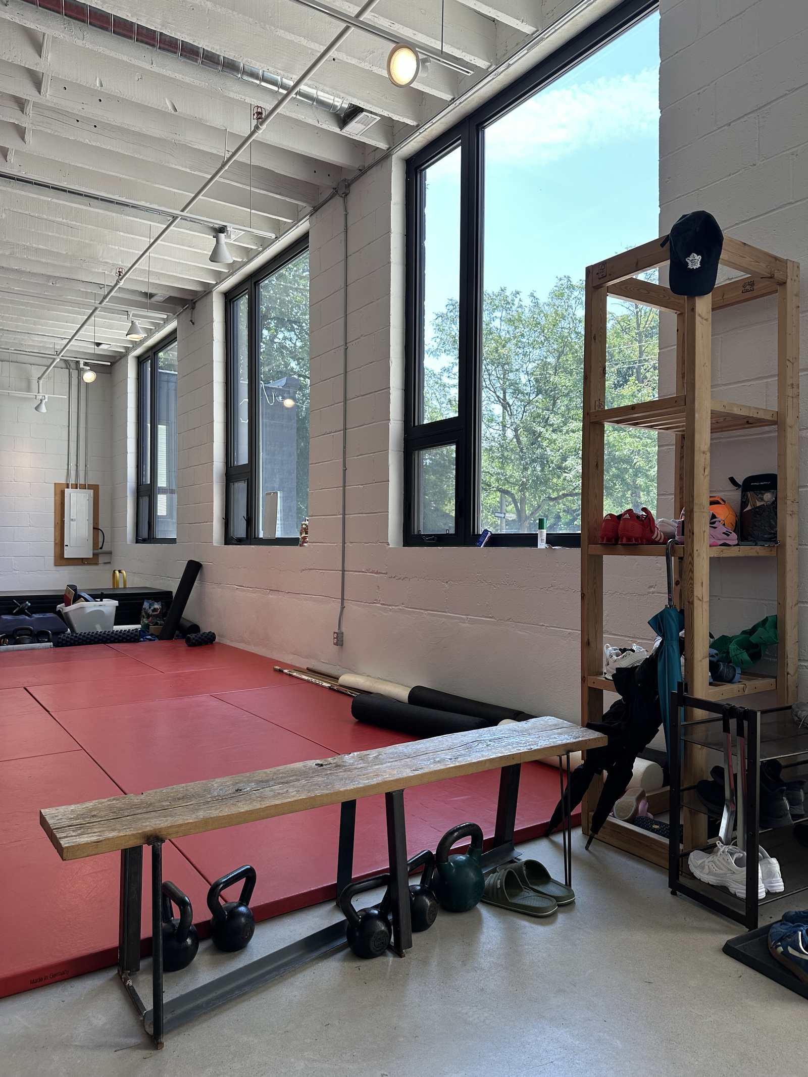The warm-up area at 91 Walnut Avenue, with a bench and red mats